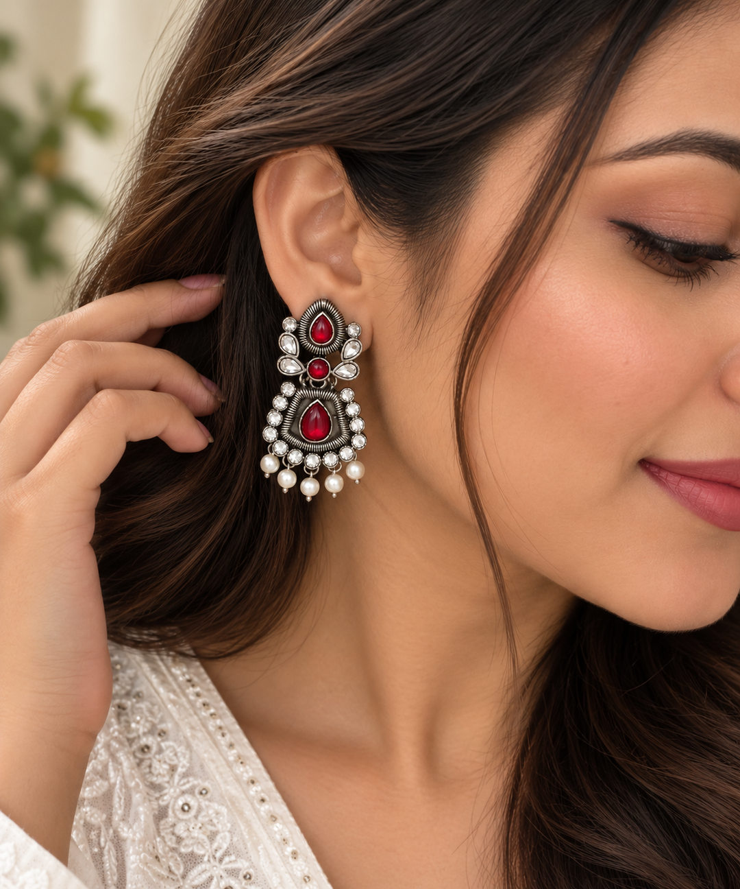 Oxidised silver earrings with red teardrop stones and clear stone detailing